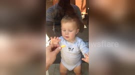 Baby tries to eat Cheeto through glass door