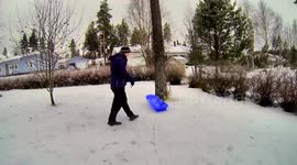 Dad pulls son on a sled very fast - watch what happens.