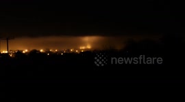 Fog rolling over church and light pillar