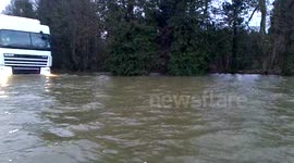 Big white truck drives through deep flooding on The Windsor Road Egham