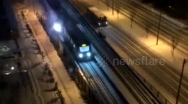 Sparks appear as train rolls on snow-covered track