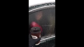 Woman punches through ice sheet to grab drink from car