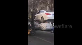 Driver refuses to leave his vehicle while being forklifted