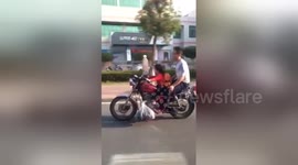 Girl drives father's motorcycle on road in China