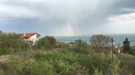Tiny rainbow over the sea (time-lapse)