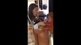 Mother gives baby orange juice for the first time