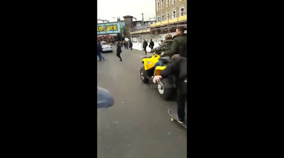 Person falls of skateboard after hiking a ride with quad