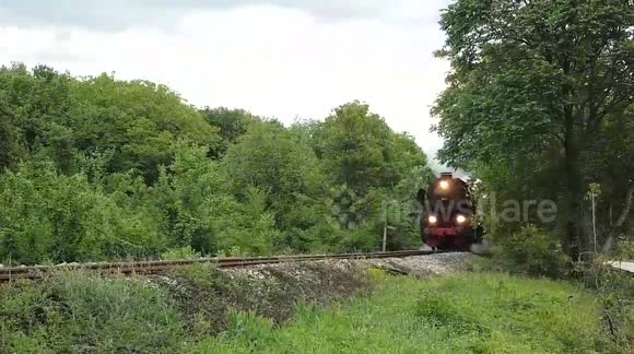 Capturing a steam locomotive passing by and a group shooting a video clip in its back