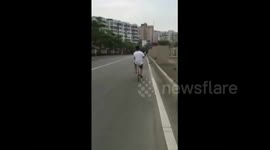 江门 男子“边骑单车边看报”吓怕路人