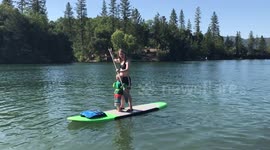 two year old paddle boards with mom