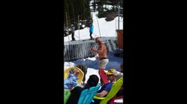 Shirtless man really enjoys a dance in the sunshine at ski resort