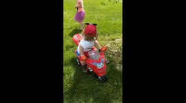 Boy, 2, crashes toy motorbike while looking at girl