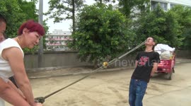 Kung fu master puts hooks in eye sockets to pull three people on a cart