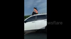 Woman filmed sitting on car roof on a motorway