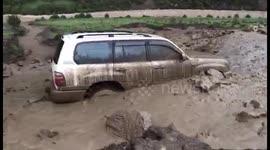 茂县山体垮塌堵塞河道  河水外溢夹杂泥沙冲刷着一辆越野车