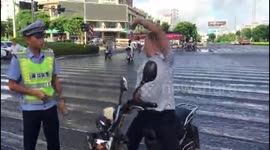 Unlicensed scooter rider dances on road after stopped by police, trying to escape punishment  in  China