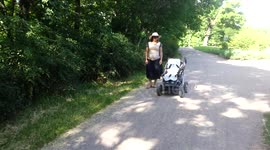 The baby is pushing the baby carriage