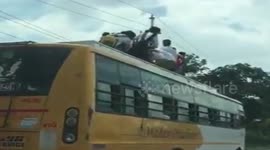 Indian school children risk lives by riding on bus roof