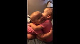 Twin baby girls giving each other hugs