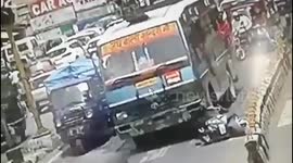 Scooter rider walks away after falling under bus