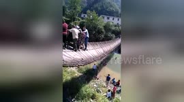 Suspension bridge tips over sending tourists into river