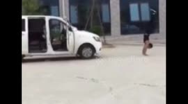 Kung fu master pulls minibus as he walks on his hands