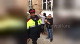 Catalan voters applaud arrival of local police at polling station