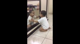 Cute baby amused to see himself in mirror