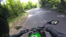 Motorbike comes round corner, confronted with double decker bus.