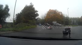 Man falls off moped on wet roundabout