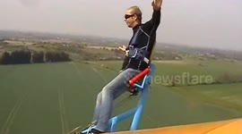 Fearless British man flies on top of bi-plane