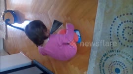 The baby is cleaning  the house
