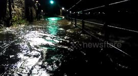 Father and Son wade through flood waters