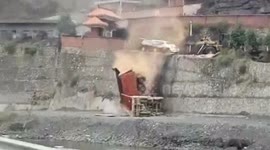 Truck loader pushes vehicles off 10-metre-high platform in dispute