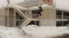 Guy skiing falls off two story parking garage