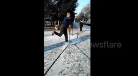 Man performs precarious workout balanced on iron chain