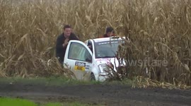 Rally car getting stuck in corn field and being pushed out by spectators