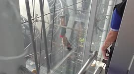 Tourist hanging upside down from airport cables