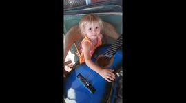 Baby girl playing guitar and singing