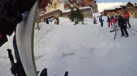 Two girls fall over at the end of day skiiing