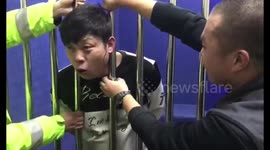 Drunk man gets head stuck in guardrails in police detention