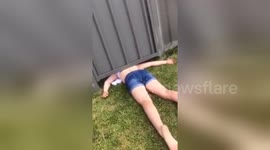 Girl gets stuck under fence