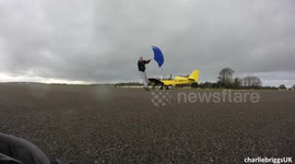 Skateboarder with umbrella pulled FAST by strong wind