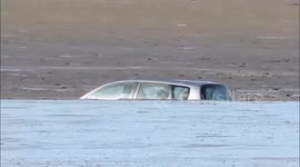 Family-of-five rescued after parking on a beach - only for their car to be swamped and totally destroyed by the incoming tide