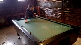 Kickboxer playing pool with legs.