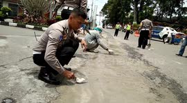 Indonesian police repair damaged roads