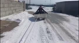 Two men being towed in a boat after snowfall
