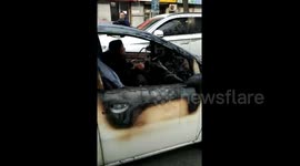 Woman calmly drives burnt-out car on road in northern China
