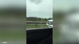 Football coach Phil Neville is forced to apologise after being snapped using mobile phone behind wheel of £70,000 car