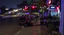 Two tuk tuk drivers fighting outside restaurant